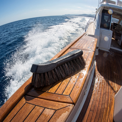 premium marine detailing brush on teak deck with ocean water in background